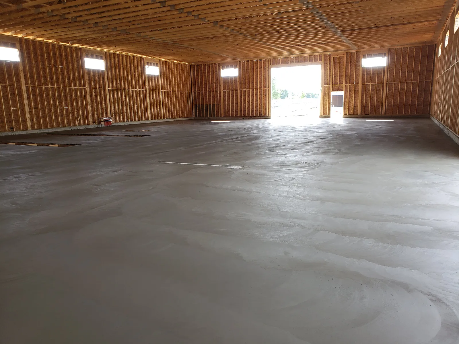 Large commercial concrete floor framed and prepped for placement inside a steel building