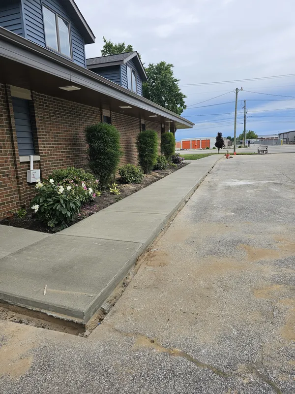 Concrete sidewalk poured alongside a commercial brick building