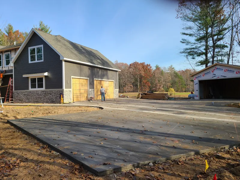 Concrete driveway running between a home and its detached garage