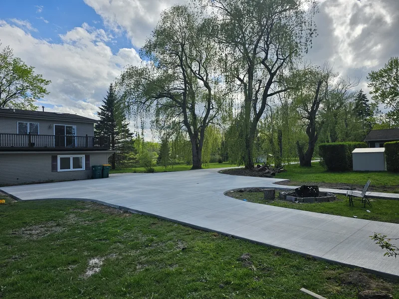 Curved concrete driveway near a backyard fire pit