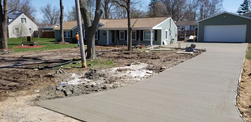 Fresh broom-finished concrete driveway and walkway at a Saginaw-area ranch home
