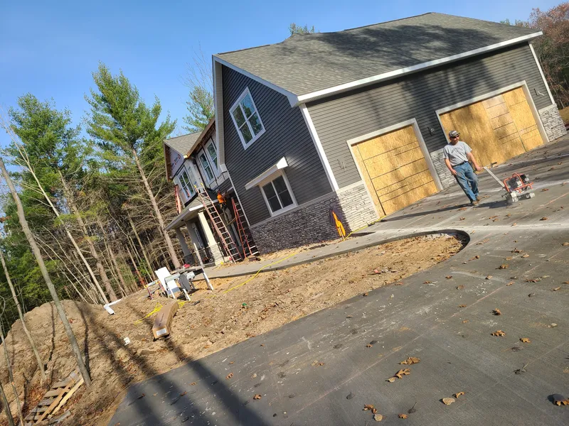 Concrete driveway at a gray-sided Mid-Michigan home