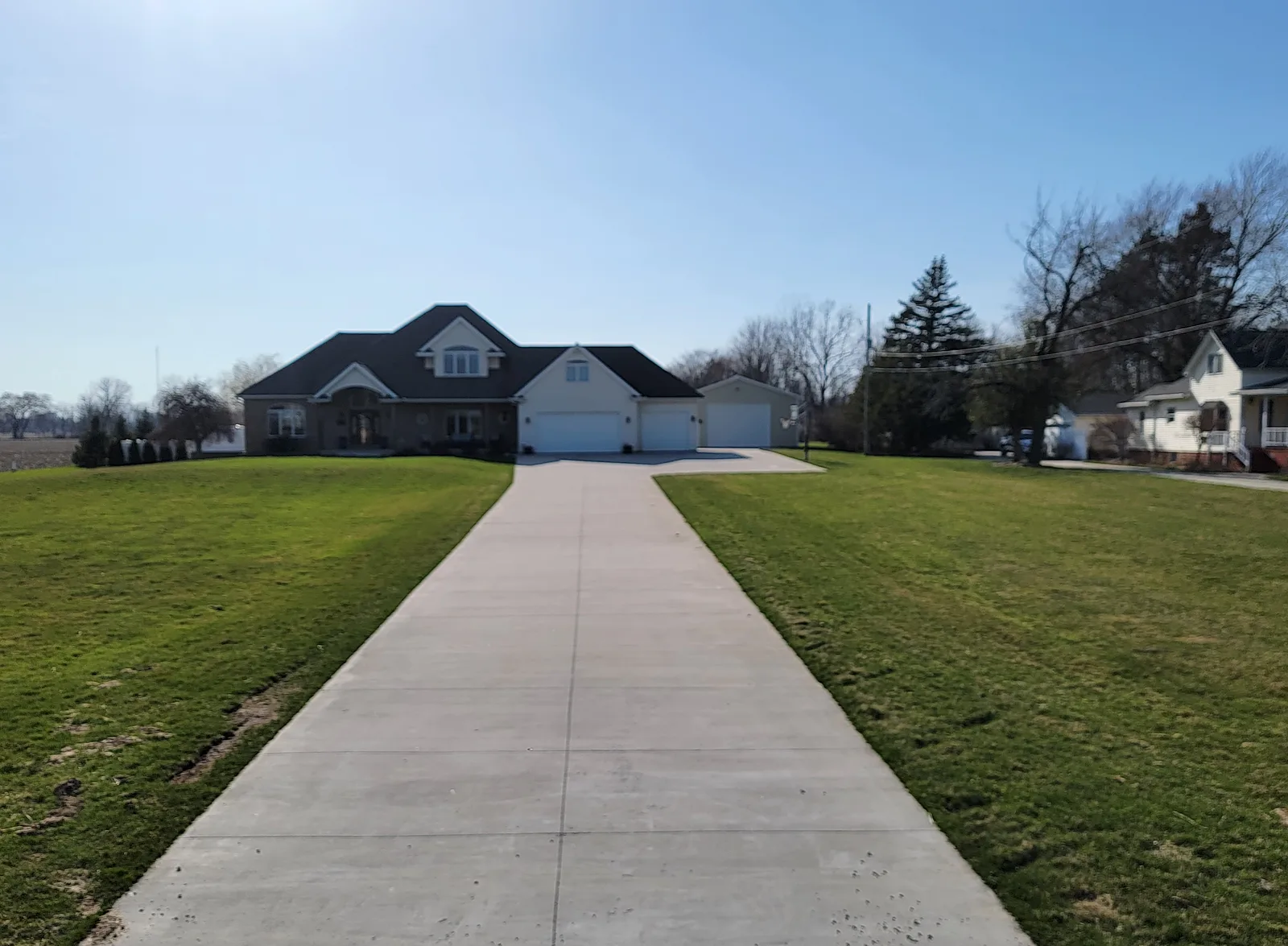 Long ribbon concrete driveway leading to a Mid-Michigan estate