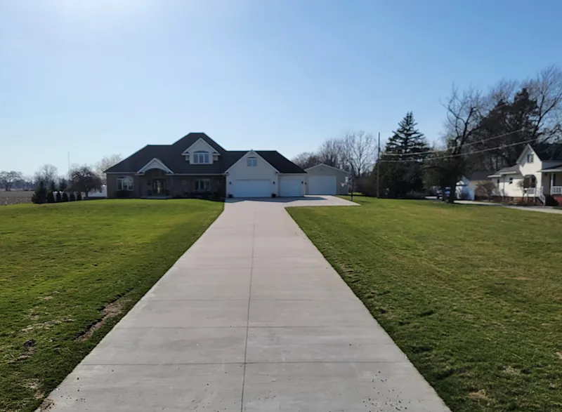 Long ribbon concrete driveway leading to a Mid-Michigan estate