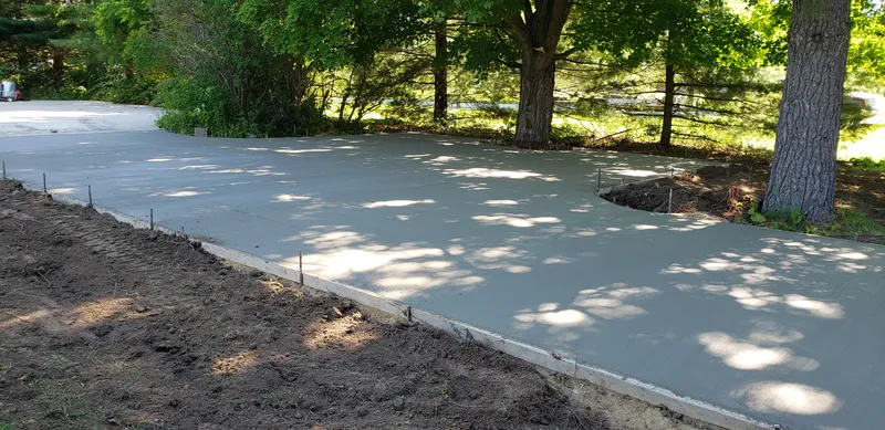 Concrete driveway with an extra parking pad beside a Mid-Michigan home