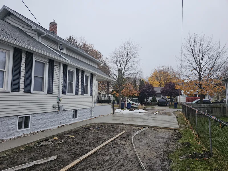 Concrete driveway along the side of a gray-sided home