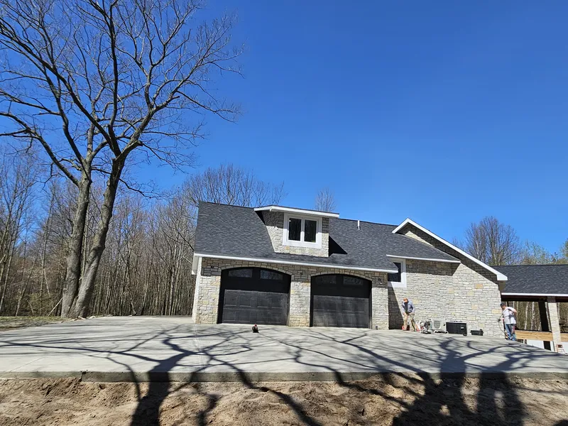 Side view of a concrete driveway at a stone-front home