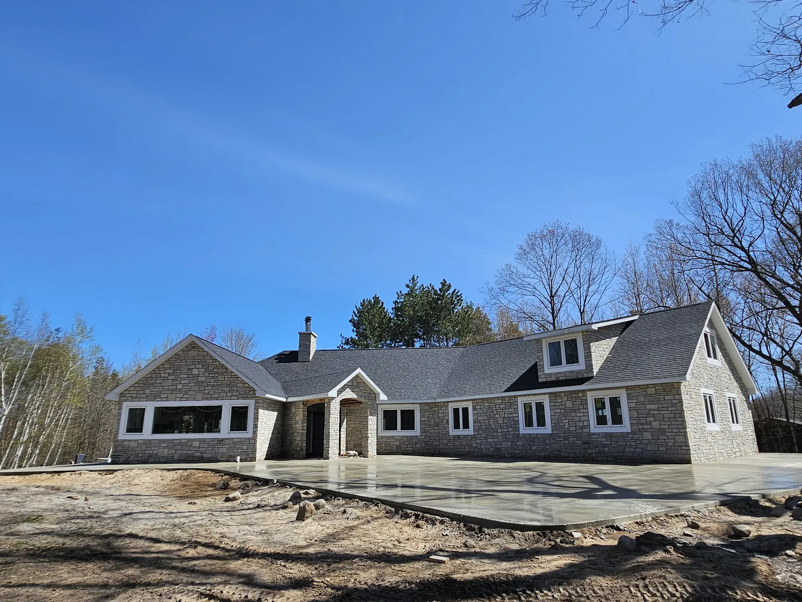 Concrete driveway at a stone-front ranch home in Mid-Michigan