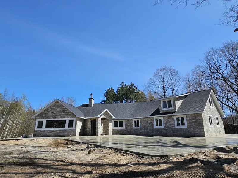 Concrete driveway at a stone-front ranch home in Mid-Michigan
