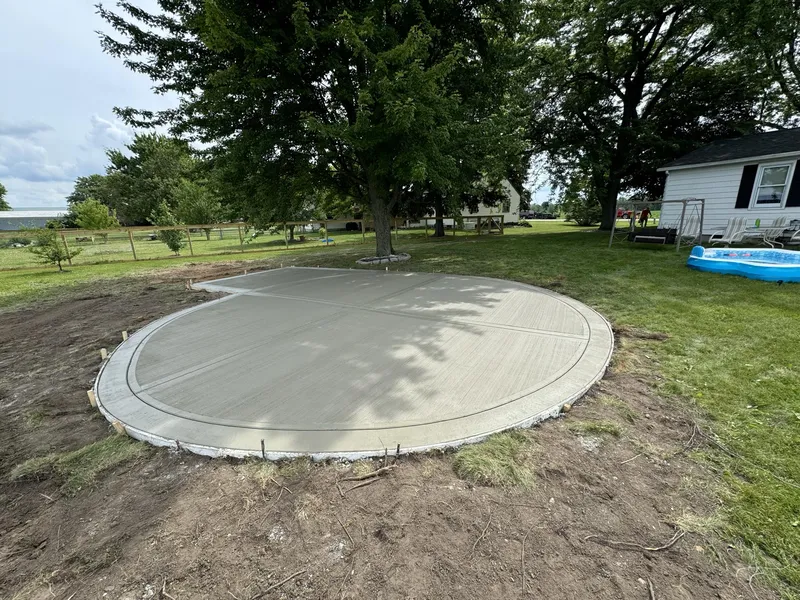 Round concrete pad poured around a backyard tree