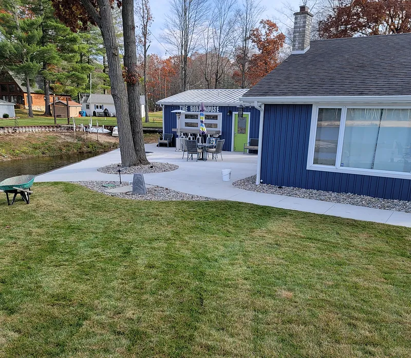 Concrete patio and walkway between a boat house and lawn