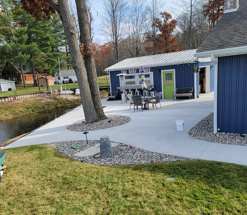 Wide concrete patio surrounding a waterfront boat house