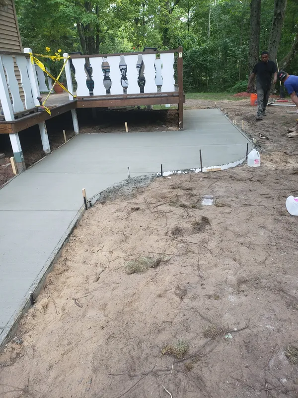 Concrete patio beside a raised deck in a Mid-Michigan backyard