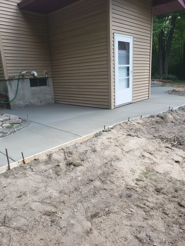 Concrete patio wrapping the corner entry of a Mid-Michigan home