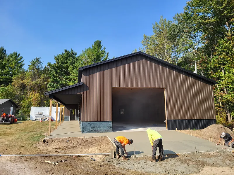 Crew finishing the concrete apron at a pole barn pour