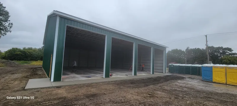 Exterior of a multi-bay pole barn with fresh concrete aprons