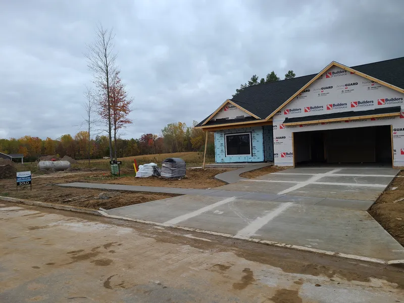Concrete sidewalk and driveway apron under construction at a new home