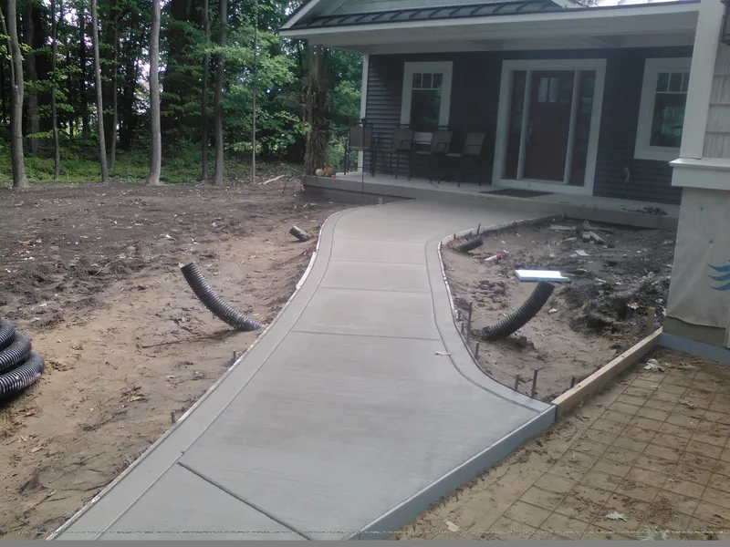 Curved concrete sidewalk to the porch of a modern home