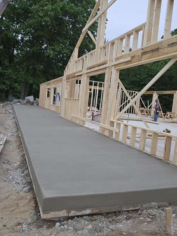 Raised concrete walkway along a framed new-construction house