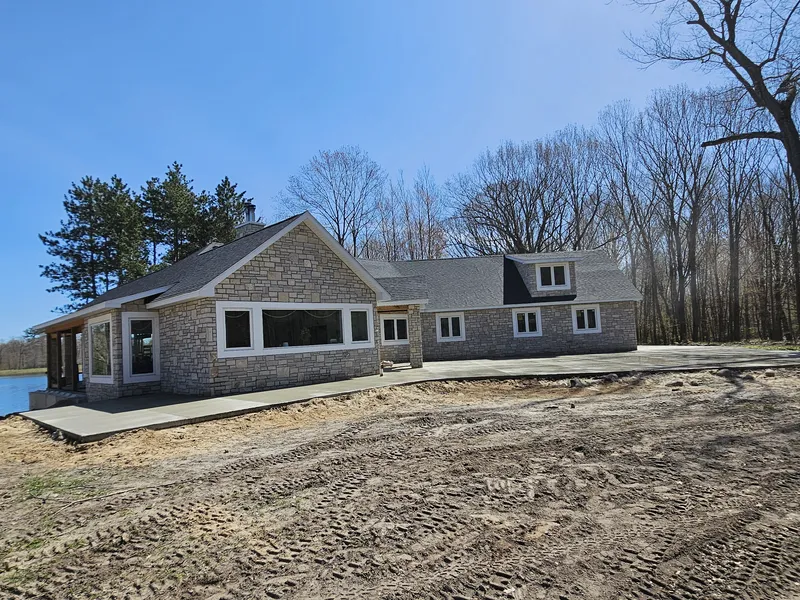 Concrete walkway at a stone-accented lake home