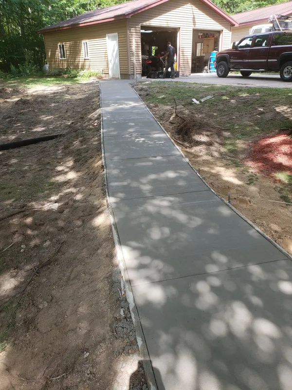 Concrete sidewalk connecting a home's entry to an attached garage in Mid-Michigan