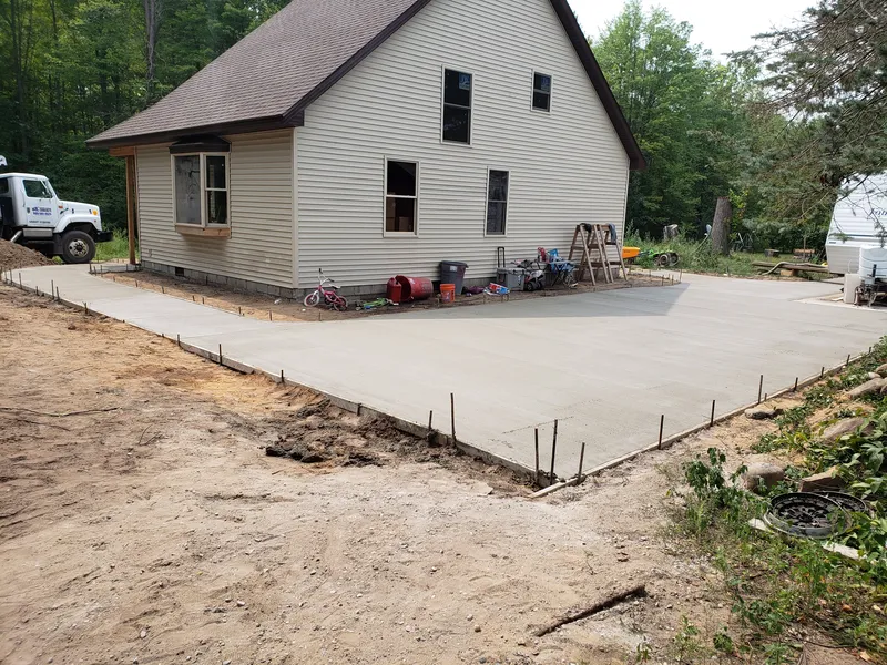 Poured concrete slab alongside a white farmhouse in rural Michigan