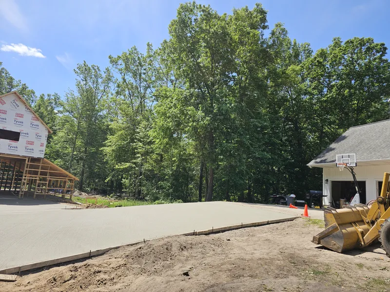 Concrete slab placement with a loader at a new home build