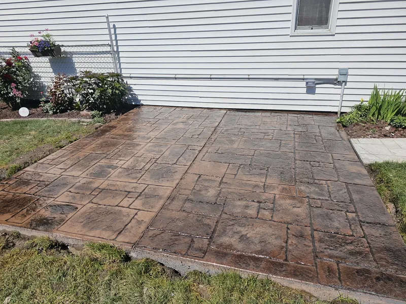 Brown ashlar-slate stamped concrete patio beside a Bay City home