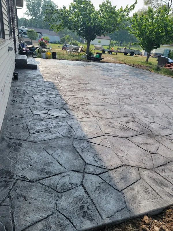 Charcoal random-flagstone stamped concrete patio in a Mid-Michigan backyard